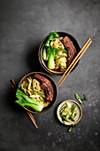 Ramen, pork belly and bok choy with black background