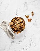 Bowl of Homemade Kale Chips on Marble Background with Grey Napkin