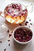 Herbal tea made from rose petals with dried flowers and teapot in close-up