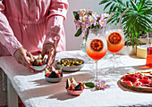 Aperol Spritz cocktail, on pale pink linen tablecloth, shade, sunlight, summer drink in a glass