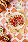 Ricotta- und Parmaschinken-Toast mit Balsamico-Nieselregen und Kresse auf einem gekachelten Hintergrund