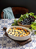 Rote Weintrauben-Clafoutis, französische Küche. auf einem Tisch aus Keramikfliesen mit blauem Muster