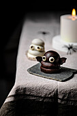 Fledermaus-Süßigkeit über dem Tisch für Halloween; hergestellt aus Keksen, Dulce de Leche und dunkler Kuvertüre.