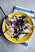 Tasty traditional Ukrainian dumplings with blueberry and sour cream