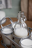 Hausgemachtes Bio-Horchata-Getränk, serviert in durchsichtigen Gläsern und Flaschen auf einem Holztisch in einer rustikalen Küche