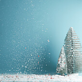 Winter, Weihnachten oder Neujahr Hintergrund mit Tannenbäumen und fallendem Schnee auf blau