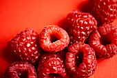 Frische, süße, rote Himbeeren, die zusammen angeordnet sind und das Konzept der gesunden Ernährung darstellen
