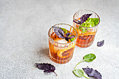 Cocktailglas mit Tonic und frischen Basilikumblättern