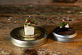 Exquisites Fusionsgericht, zubereitet mit lokalen und saisonalen Produkten, serviert in einem Michelin-Stern-Restaurant in Zermatt, Schweiz, das kulinarische Kunstfertigkeit und Innovation demonstriert