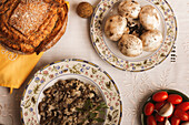 Traditionelles hausgemachtes Pilzrisotto mit Brot auf einem rustikal gedeckten Tisch mit frischen Zutaten