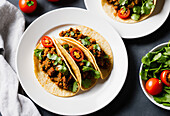 High angle of served appetizing Mexican tacos with spicy chili peppers and cilantro on plate. Generative AI