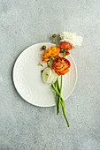 Top view of Table setting with Ranunculus flowers on concrete background
