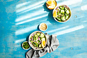 From above of healthy vegetables salads with organic cucumber, red onion, coriander and chopped nuts placed in a blue concrete table