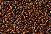 Draufsicht auf eine Kulisse, die Hälften von dunkelbraunen Kaffeebohnen mit angenehmem Duft darstellt