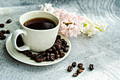 Cup of black coffee served on concrete table in the sunny morning