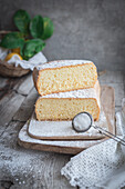 Von oben Holzbrett mit Pasiego-Kuchen, einem typischen Kuchen aus Katalonien in Spanien, bestreut mit Zucker auf rustikalem Holztisch