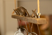 Nahaufnahme einer Reihe von hängenden Küchenutensilien, darunter Löffel und ein Sieb, vor einem Weichzeichner-Hintergrund