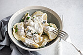 Top view of a tasty traditional Ukrainian dumplings with cherry and sour cream with mint