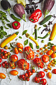 Top view of various fresh ripe vegetables composed in gradient colors over white fabric on table