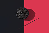 Draufsicht auf schwarze Spaghetti in einer Schüssel auf schwarzem und rotem Hintergrund neben Stäbchen