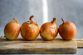 Raw organic onion heads on the kitchen table before cooking