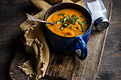 Tasty pumpkin cream soup with organic herbs and seeds in blue vintage ceramic bowl