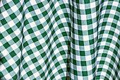 Full frame background of bright green and white checkered tablecloth arranged on table