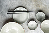 From above set of grey ceramic crockery on a concrete background in the same color
