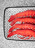 Nahaufnahme von oben von frischen rohen Shrimps auf einem Tablett über einem grauen Marmortisch