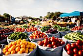 Wide angle view of bazaar with heap of fresh ripe fruits and vegetables with tomatoes and spinach placed on stall in local market