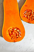 Von oben von saftigen Kürbis in zwei Hälften gespalten orange mit Kernen und Fleisch auf dem Tisch platziert