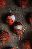 Top view of delicious fresh and opened ripe lychee fruits with transparent juice on smooth surface with grey background