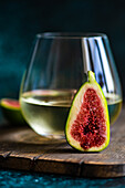 Glass of cold white dry wine and fig fruit halfs as a appetizer before dinner