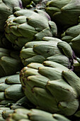 Full frame of bunch of fresh green artichokes placed on stall in local market