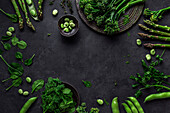Overhead-Komposition von organischen vegetarischen gesunden Grünzeug von Trauben und Schoten, Blätter und Bohnen auf dem Tisch