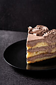 From above of piece of delicious truffle chocolate cake served in plate on black table