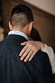Unrecognizable bride with delicate wedding ring on finger keeping hand on shoulder of beloved husband during wedding dance