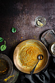 Top view of dirty empty plate with spoon after eaten chickpeas curry food at table with kitchenware