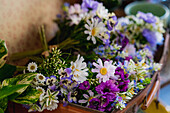 Tender colorful bouquet of assorted fresh wildflowers placed in basket in floral store