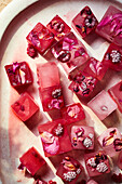 Top view of ice cubes with frozen flower petals made for cold Italian drink