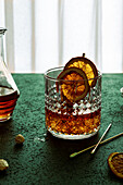 Komposition aus kaltem, eiskaltem Likör, garniert mit einer Orangenscheibe und auf dem Tisch platziert