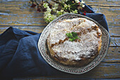 Appetitliche Bastilla mit aromatischen Gewürzen auf dem Tisch in der Nähe eines Blumenzweigs während des Ramadan-Festes