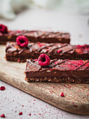 Close up of several chocolate bars with raspberry on a table