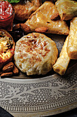 High angle of assorted tasty Arabic food with salsa and fresh mint leaves near almonds during Ramadan holidays