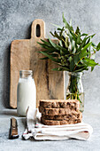 Rye fresh bread and homemade almond milk in vintage glass bottle on the stone kitchen table