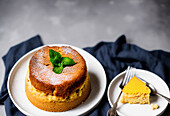 Appetizing homemade souffle served on plate with fresh mint leaves and sugar powder