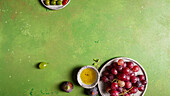 Top view of bunch of delicious fresh juicy red and green grapes served on plate on green background