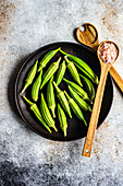 From above preparation for cooking of bamia vegetable with himalayan salt on concrete background