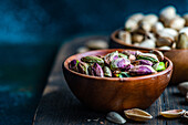 Raw organic pistachio nuts in the bowl on dark background