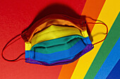 Helle Textilmaske mit gestreiftem Regenbogenornament während der Pandemie COVID 19 von oben